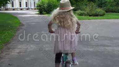 优雅的女孩子，带帽子，穿粉色连衣裙，在户外骑自行车
